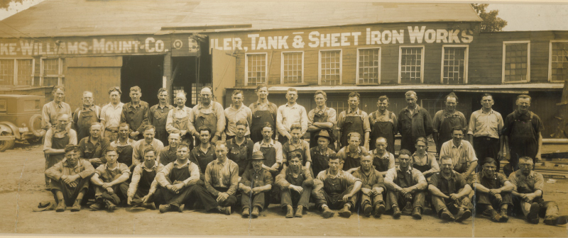 Drake-Williams Steel Inc. vintage photo showing Drake-Williams Mount Co employees posing for a photo in front of their old building.