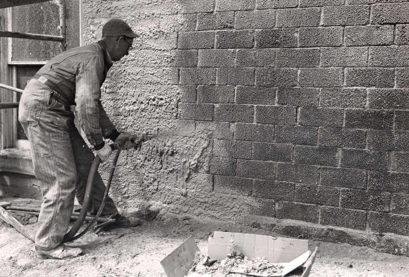 RAM Construction Services vintage black and white photo of spraying material on the exterior of a building.