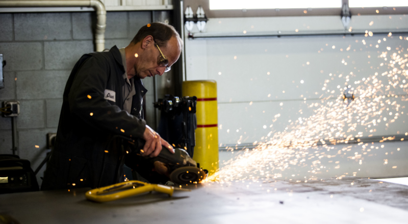 Vermeer Midwest employee grinding a part with sparks flying.